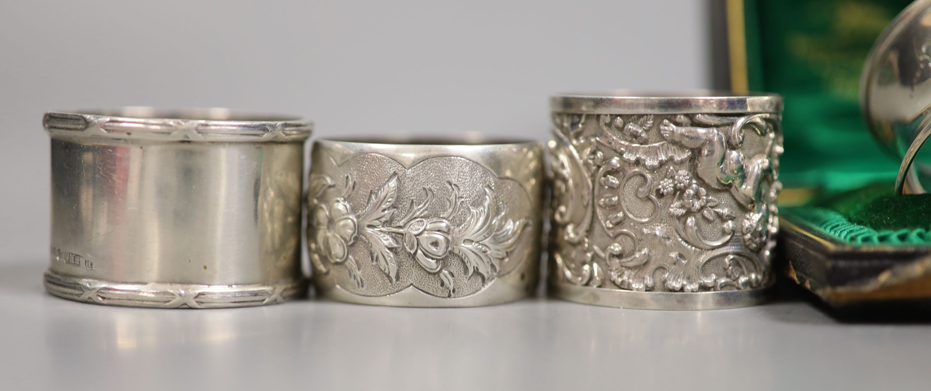 A set of four Victorian embossed silver napkin rings, A & J. Zimmerman, Birmingham, 1889 and four other silver napkin rings including one cased, 7.5oz.